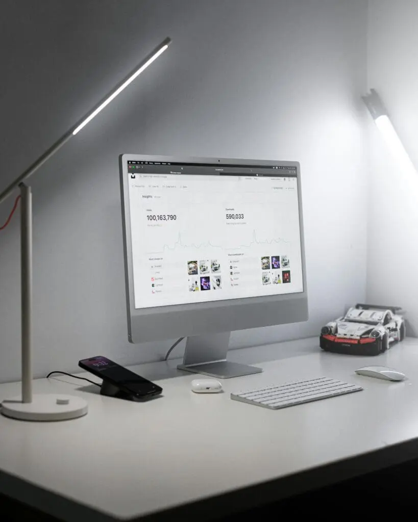Modern LED desk lamp next to monitor and keyboard