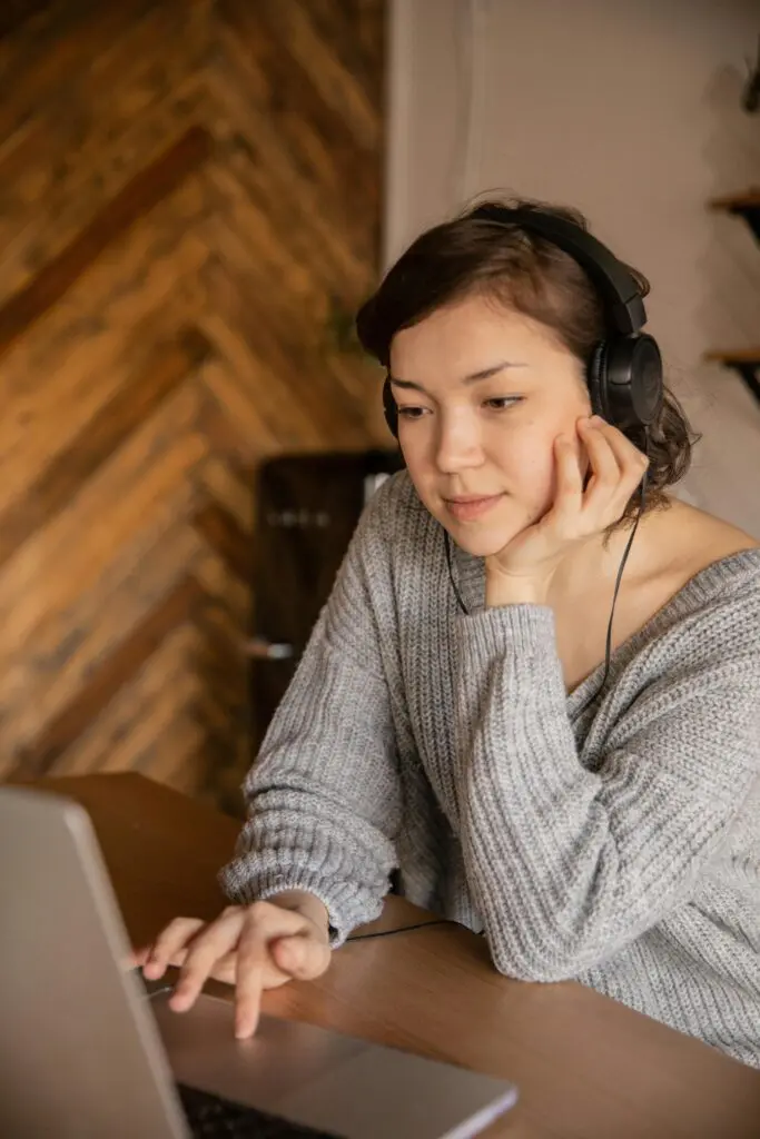 A person wearing top-rated noise-cancelling headphones while working from a home office, demonstrating improved focus and productivity in a hybrid work environment